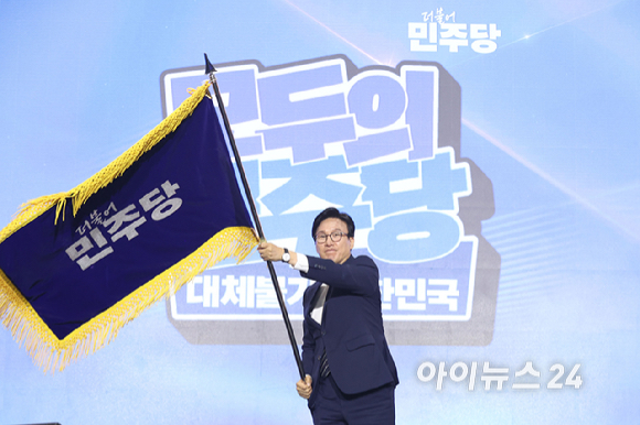 김민석 더불어민주당 신임 당 대표가 17일 대전 컨벤션센터에서 열린 제3회 더불어민주당 정기 전국당원대회에서 당 대표로 선출된 뒤 당기를 흔들고 있다. [사진=곽영래 기자]
