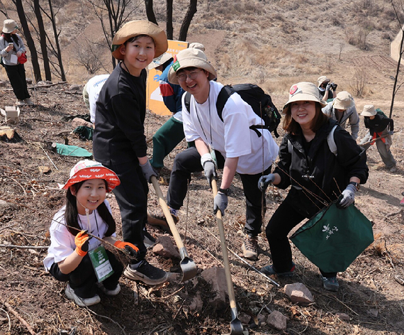 유한킴벌리가 28일 경북 안동 산불피해지에서 '우리강산 푸르게 푸르게 2026 신혼부부 나무심기'를 진행했다. 참가자들이 나무심기에 열중하고 있다. [사진=유한킴벌리]
