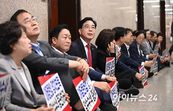 국민의힘 송언석 원내대표와 의원들이 3일 서울 여의도 국회에서 긴급의원총회 및 특검 압수수색 규탄대회를 마친 뒤 원내대표실 앞에서 압수수색 대비 연좌농성을 하고 있다. [사진=곽영래 기자]
