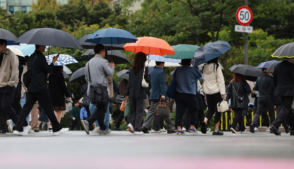 서울 종로구 광화문네거리에서 우산을 쓴 시민들이 길을 건너고 있다. [사진=연합뉴스]
