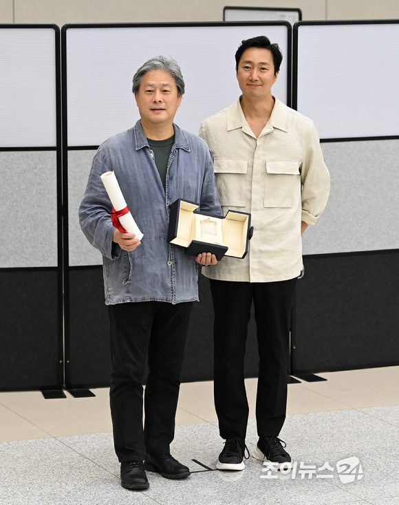 제75회 칸 국제영화제에서 영화 '헤어질 결심'으로 감독상을 받은 박찬욱 감독과 배우 박해일이 30일 오후 인천국제공항 제2여객터미널을 통해 귀국한 후 기념촬영을 하고 있다. [사진=김성진 기자]