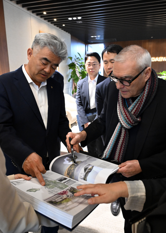 도미니크 페로가 본인의 작품집을 정원주 대우건설 회장에게 설명하고 있다 [사진=대우건설]