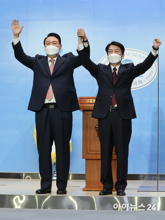 윤석열 국민의힘 대선 후보와 안철수 국민의당 대선 후보가 3일 오전 서울 여의도 국회 소통관에서 단일화 기자회견을 마치고 손을 들어올리고 있다. [사진=김성진 기자]