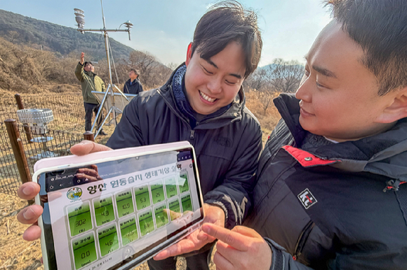 KT와 국립생태원 직원들이 원동습지에 자동기상관측장비를 설치하고 측정 상황과 데이터를 태블릿 PC로 모니터링하고 있다. [사진=KT]