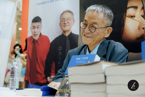 지난 6월 26일 서울 강남구 코엑스에서 열린 서울국제도서전에서 전경철 작가가 에세이 '안녕, 피터팬'에 사인하고 있다. [사진=카카오]