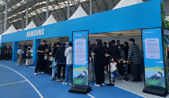 '2026 용인 사이버 과학축제' 첫째 날인 3일 삼성전자 부스에는 청소년과 어린이 등 지역 주민 6000여 명이 방문했다. 삼성전자 팹 인근 오산천에 돌아온 수달 가족을 모티브로 제작된 캐릭터 '달수'와 사진을 찍는 어린이들. [사진=삼성전자]