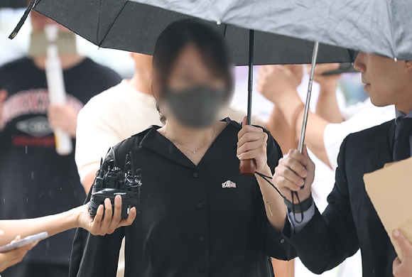 6&middot;3 지방선거 개표소로 사용된 올림픽공원 핸드볼경기장 문 앞에서 체육단체 직원들의 장내 사무실 진입을 막아 업무 방해 혐의를 받는 30대 여성이 지난 21일 구속 전 피의자 심문(영장실질심사)를 위해 서울 송파구 서울동부지방법원으로 출석하고 있다. [사진=연합뉴스]