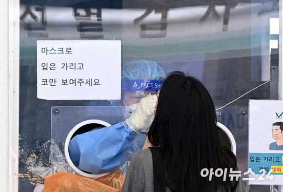 0시 기준 신종 코로나바이러스 감염증(코로나19) 신규 확진자가 2008명으로 집계된 17일 오후 서울 중구 서울역 광장에 설치된 임시선별진료소에서 시민들이 코로나19 검사를 받고 있다.