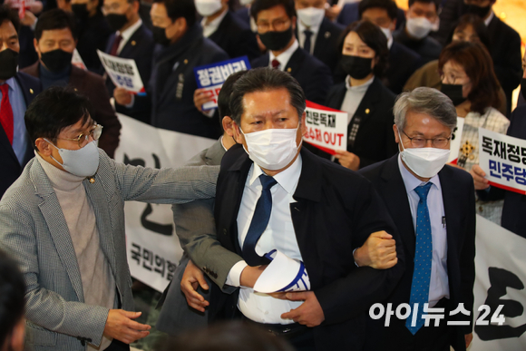 정청래 더불어민주당 의원이 지난해 12월10일 오후 서울 여의도 국회에서 열린 본회의에 참석하는 중에 피켓 시위를 하는 국민의힘 의원들 중에 자신에게 욕설을 한 의원이 있다며 항의하고 있다.