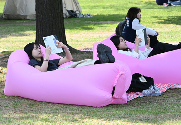지난 9일 경기도 수원시 성균관대학교 자연과학캠퍼스 잔디밭에서 '북 피크닉' 행사에 참여한 학생들이 독서를 하고 있다. [사진=뉴시스]
