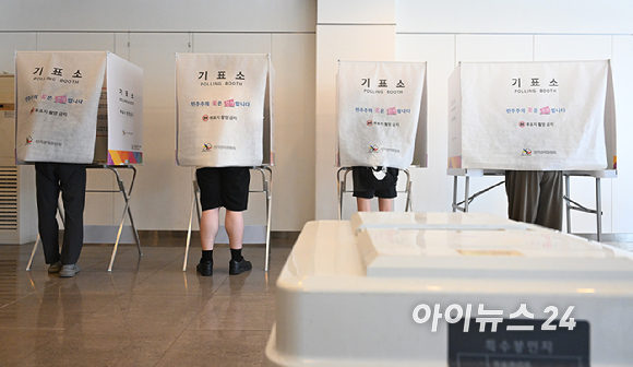 제9회 전국동시지방선거 및 국회의원 재&middot;보궐 선거가 시작된 3일 서울 광진구 기아자동차 대공원대리점에 마련된 투표소에서 시민들이 투표를 하고 있다. [사진=곽영래 기자]