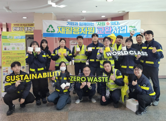 오비맥주 청주공장에서 임직원들이 재활용자원 교환사업에 참여하고 기념사진을 찍고 있다. [사진=오비맥주]