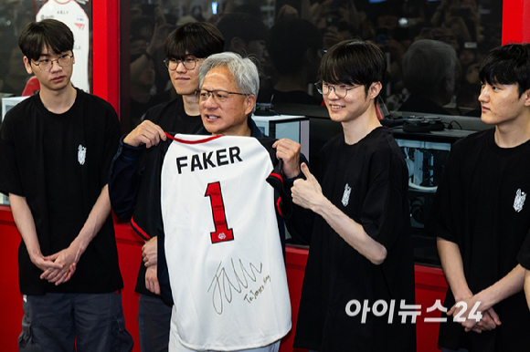젠슨 황 엔비디아 최고경영자(CEO)가 5일 서울 마포구 &lsquo;T1 베이스 캠프&rsquo;를 방문해 &lsquo;페이커&lsquo; 이상혁을 비롯한 e스포츠 구단 T1의 리그 오브 레전드(LoL) 선수단을 만나서 &lsquo;페이커&rsquo;의 사인이 담긴 기념품을 선물 받고 있다. [사진=곽영래 기자]
