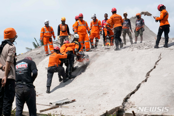 22일(현지시간) 인도네시아 서자바주 치안주르에서 구조대가 지진 희생자 시신을 수습하기 위해 전기톱으로 붕괴 건물 시멘트를 뚫고 있다. 2022.11.22. [사진=치안주르=AP/뉴시스]