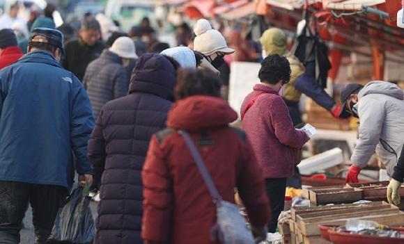 경남 창원시 마산합포구 마산어시장에서 두꺼운 패딩 점퍼 등을 착용한 시민이 찬 바람을 막으며 이동하고 있다. [사진=연합뉴스]