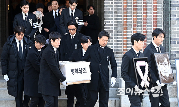 9일 서울 중구 명동성당에서 열린 故 안성기의 장례 미사가 끝난 뒤 영결식을 위해 고인의 영정과 금관문화훈장을 든 배우 정우성, 이정재가 영결식장으로 향하고 있다. [사진=곽영래 기자]