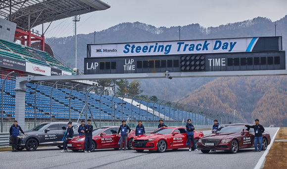 HL만도 스티어링 BU 관계자들이 강원도 인제군 스피디움에서 SbW 서킷 택시와 함께 기념 촬영을 하고 있다. [사진=HL만도]