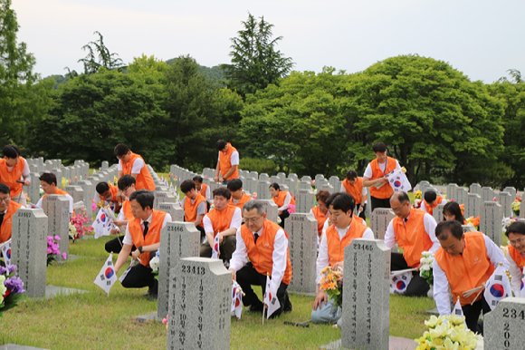 한화그룹 충청지역 봉사단이 30일 국립대전현충원에서 태극기 교체 등 봉사활동을 하고 있다. [사진=한화]