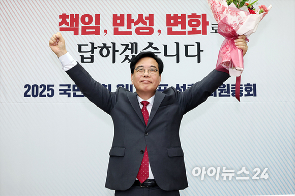 송언석 국민의힘 신임 원내대표가 16일 오후 서울 여의도 국회에서 열린 2025 국민의힘 원내대표 선출 의원총회에서 꽃다발을 든 채 손을 들어올리고 있다. [사진=곽영래 기자]