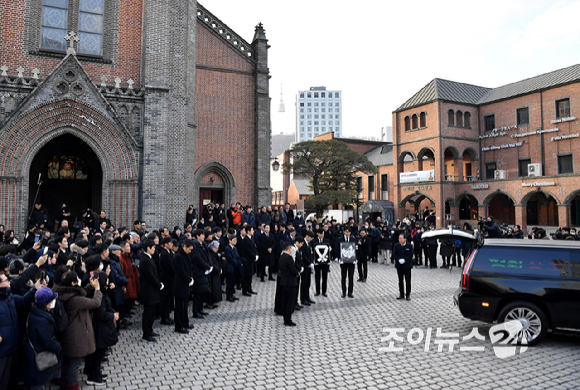 9일 서울 중구 명동성당에서 열린 故 안성기의 장례 미사가 끝난 뒤 영결식을 위해 고인의 영정과 금관문화훈장을 든 배우 정우성, 이정재가 영결식장으로 향하고 있다. [사진=곽영래 기자]