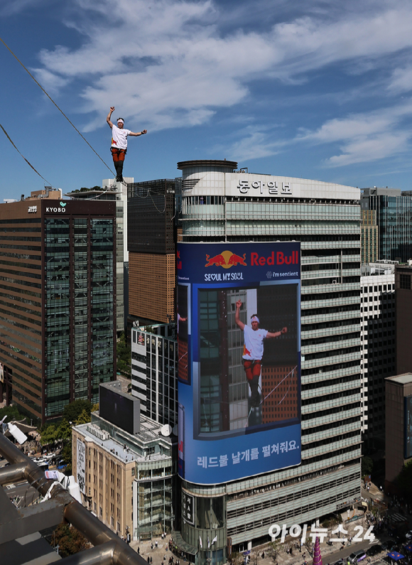 세계적인 슬랙라인 선수 얀 루스(Jaan Roose)가 1일 서울 광화문 사거리 상공 120m 높이에서 '레드불 서울 줄타기' 퍼포먼스를 선보이고 있다. [사진=정소희 기자]