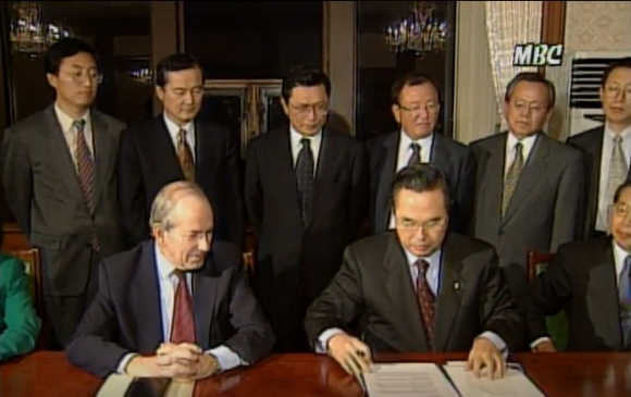 1997년 12월 3일 임창열(앞줄 오른쪽) 경제부총리와 미셸 캉드쉬(앞줄 왼쪽) IMF 총재가 550억 달러 긴급자금 지원과 관련한 양해각서에 서명했다. 당시 협상단에 참여한 고위 경제 관료들이 뒤에 도열했다. 마치 죄인처럼. [사진=MBC 뉴스]
