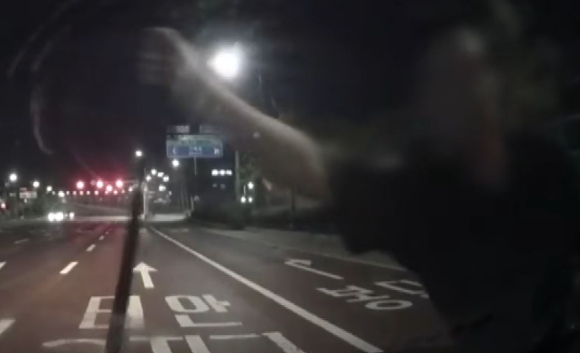 새벽 시간 한 도로에서 돌연 한 괴한을 마주해 차량까지 파손당한 남성의 사연이 전해졌다. 사진은 신원 미상의 남성이 운전자 차량을 막고 있는 모습. [사진=JTBC 방송화면 캡처]
