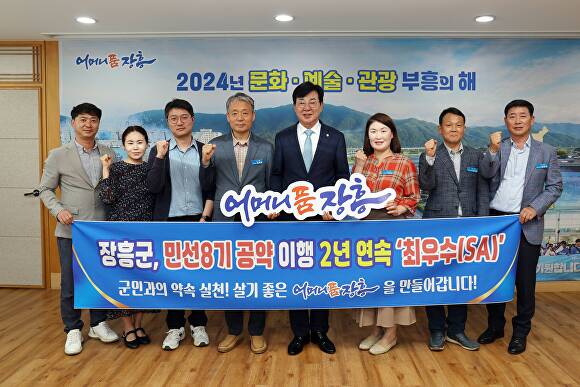 김성 장흥군수(왼쪽 네번째)가 민선8기 공약 이행 2년 연속 최우수 달성을 기념해 직원들과 사진을 찍고 있다  [사진=장흥군]