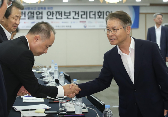 이정식 고용노동부 장관이 지난 8월 서울 중구 프레스센터에서 열린 산재사망사고 감축을 위한 건설업 안전보건리더회의에서 마창민 DL이앤씨 대표와 인사를 나누고 있다. [사진=뉴시스]