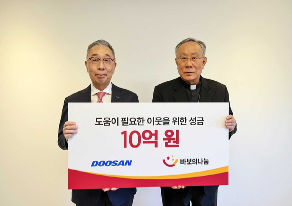 박지원 두산그룹 부회장(사진 왼쪽)과 구요비 재단법인 바보의 나눔 이사장이 3일 서울 명동성당에서 열린 성금 전달식에서 기념촬영을 하고 있다. [사진=두산]