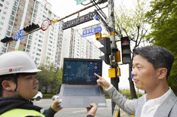 LG유플러스 관계자가 천안시에 설치된 긴급차량 출동 알림 전광판을 점검하는 모습. [사진=LGU+]
