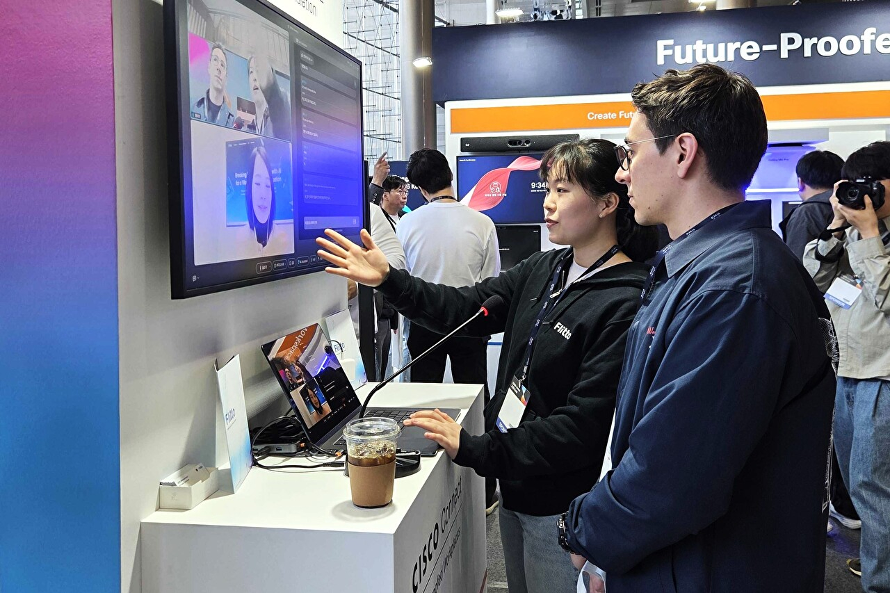 최신 IT 기술을 공유하는 시스코코리아 대표 연례 행사 '시스코 커넥트 2026 코리아'에서 플리토 부스를 방문한 외국인 참관객이 웹엑스에 탑재된 챗 트랜스레이션을 체험하고 있다. [사진=플리토]