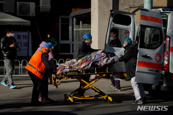 19일 중국 베이징의 한 발열 전담 병원에 한 환자가 구급차로 도착해 들것에 실려 내리고 있다. [사진=뉴시스]