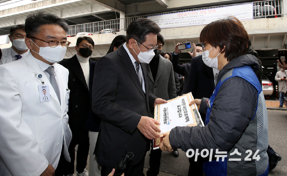 이재명 더불어민주당 대선 후보가 15일 오후 서울 동작구 서울특별시보라매병원을 현장 방문한 가운데 병원 입구에서 민주노총 공공운수노조 의료연대 서울대병원분회 소속 회원들에게 요구사항을 전달받고 있다. [사진=국회사진취재단]