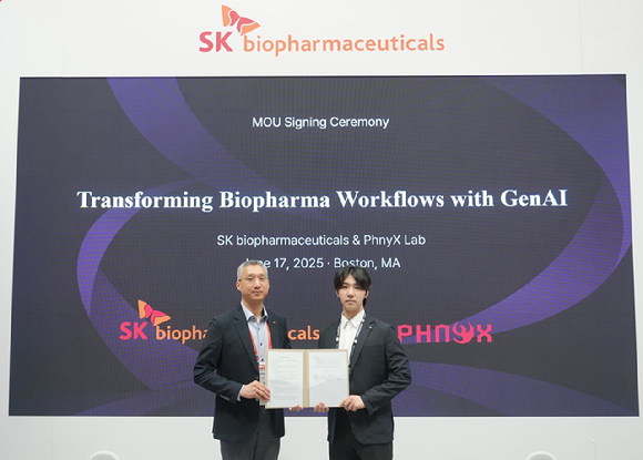 17일(미국 현지) &lsquo;BIO USA 2025&rsquo; SK바이오팜 전시 부스에서 참석자들이 AI 기반 신약 개발 MOU 기념촬영을 진행하고 있다. 왼쪽부터 SK바이오팜 유창호 전략부문장, 피닉스랩 배민석 대표. [사진=SK바이오팜]