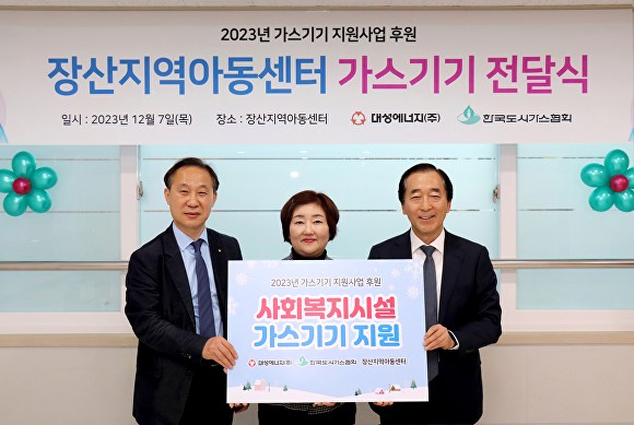 정희용 한국도시가스협회 전무와 강선희 경산지역아동센터장, 윤홍식 대성에너지 대표이사(왼쪽부터)가 전달식 후 기념촬영을 하고 있다. [사진=대성에너지]