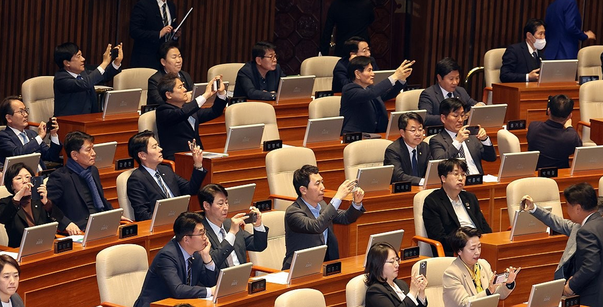 더불어민주당 의원들이 지난 3월 20일 국회 본회의장에서 공소청법안(대안)이 통과되자 휴대폰을 꺼내 사진을 찍고 있다. 2026.3.20 [사진=연합뉴스]