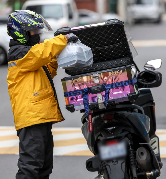 서울시내 한 주택가에서 음식배달 종사자가 배달음식을 오토바이에 넣고 있다. [사진=뉴시스]