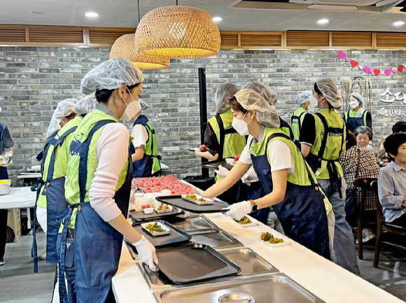 지난 18일 에어부산 객실 승무원이 종합복지관을 방문해 초복 맞이 삼계탕 나눔 봉사활동을 실시하고 있다. [사진=에어부산]