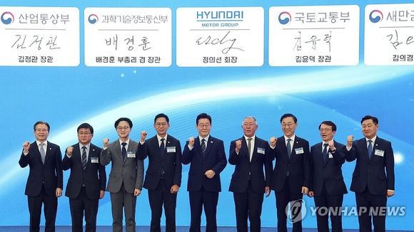 이재명 대통령이 전북 군산새만금컨벤션센터에서 열린 새만금 로봇&middot;수소&middot;AI 시티 투자협약식에서 참석자들과 기념촬영을 하고 있다. [사진=연합뉴스]