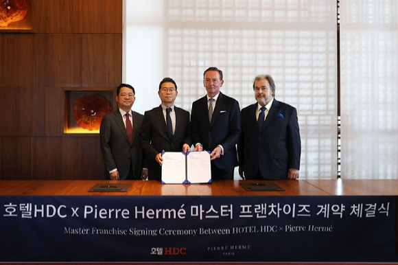 피에르 에르메 관계자와 호텔 HDC 관계자가 디저트 도입 계약 체결을 한 뒤 기념촬영을 하고 있다. [사진=호텔HDC]