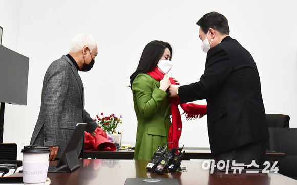 윤석열 국민의힘 대선 후보가 20일 서울 여의도 새시대준비위원회 위원장실에서 열린 영입인사 환영식에서 신지예 한국여성정치 네트워크 대표에게 빨간 목도리를 둘러주고 있다. [사진=김성진 기자]