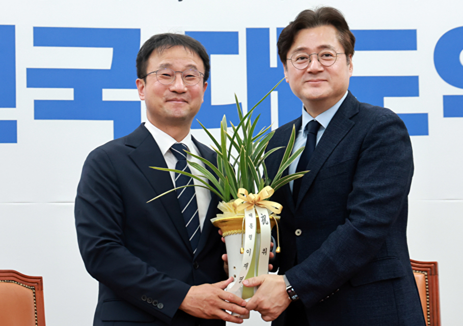 연임에 성공한 더불어민주당 한병도 원내대표가 7일 국회를 방문한 홍익표 청와대 정무수석을 만나 이재명 대통령 축하 난을 전달 받고 기념 촬영하고 있다. 2026.5.7 [사진=연합뉴스]