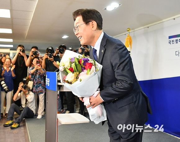 이재명 전 더불어민주당 대표가 지난 10일 오전 서울 여의도 더불어민주당 중앙당사에 당 대표 출마 기자회견에서 지지자에게 꽃다발을 받고 있다. [사진=곽영래 기자]