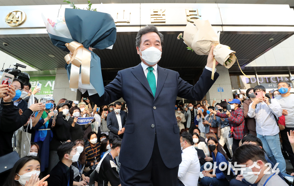 이낙연 전 더불어민주당 대표가 14일 오후 서울 여의도 대산빌딩에서 열린 필연캠프 해단식을 마친 뒤, 꽃다발을 들고 지지자들을 향해 손을 들고 있다.