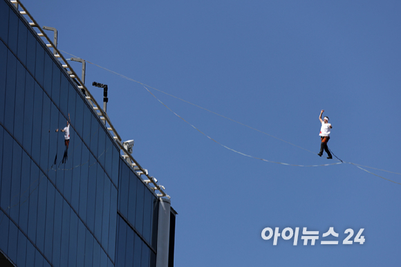 세계적인 슬랙라인 선수 얀 루스(Jaan Roose)가 1일 서울 광화문 사거리 상공 120m 높이에서 '레드불 서울 줄타기' 퍼포먼스를 선보이고 있다. [사진=정소희 기자]