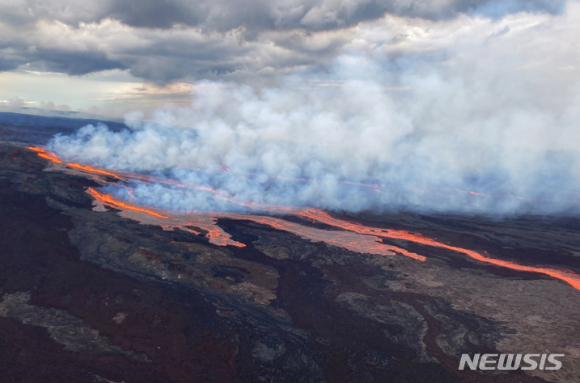 28일 새벽(현지시간) 미 하와이주 빅아일랜드에 있는 마우나로아 화산에서 용암이 흘러내리고 있다. 세계 최대 활화산인 마우나로아 화산이 용암과 함께 화산재 등을 분출하면서 미 지질조사국(USGS)은 인근 지역 주민들에게 추가 분출 상황에 대비할 것을 당부했다.  [사진=뉴시스 ]