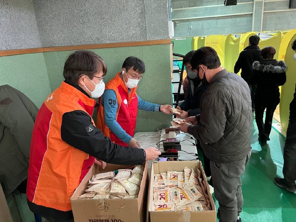  SK텔레콤 구성원들이 경북 울진 국민체육센터에 설치된 대피소에서 주민들에게 핫팩 등 생필품을 지원하고 있는 모습. [사진=SK]
