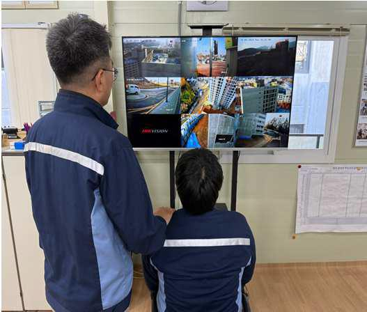 현장 근로자들이 건설현장 CCTV를 보고 있다. [사진=LH]