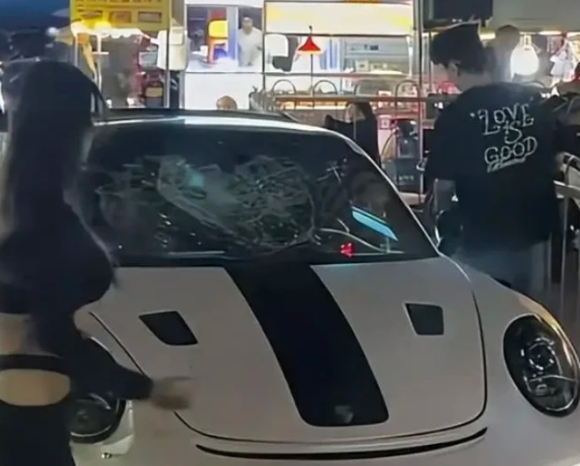 해당 여성이 흰색 포르쉐 차량 유리를 차고 있다. [사진=바이두 갈무리]